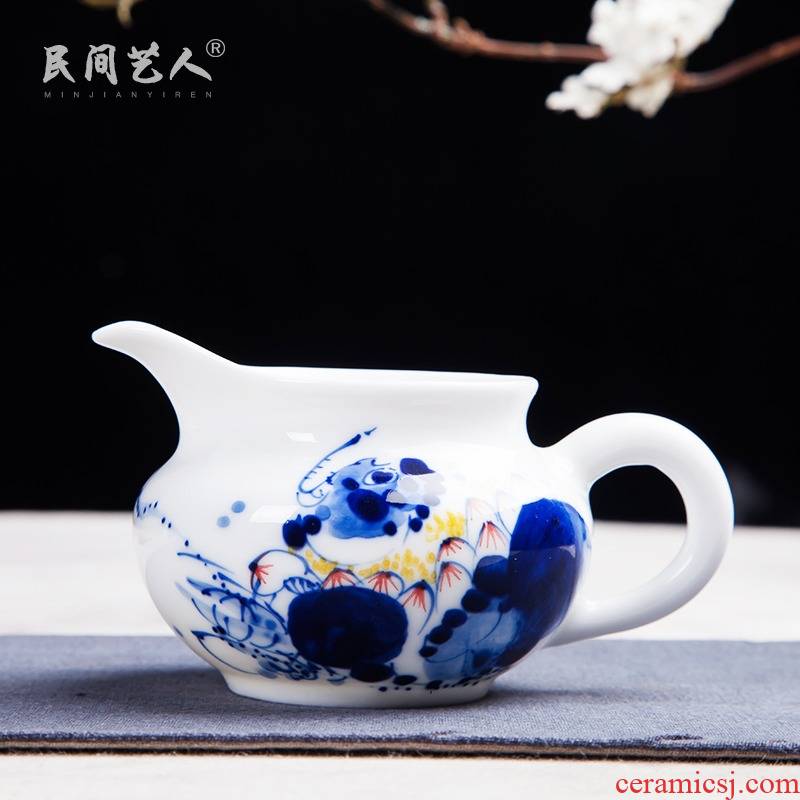 Jingdezhen hand - made ceramic fair cup of tea by hand and points tea exchanger with the ceramics cup against the hot cup of tea sea