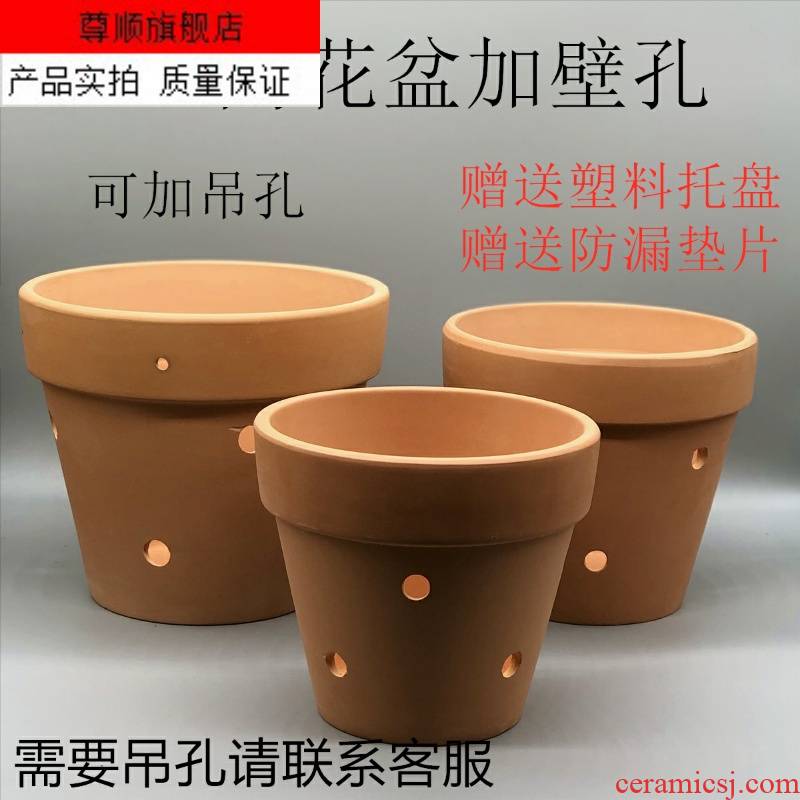 The Red clay flowerpots hanging wall made of baked clay porous coarse pottery and mud holes of large diameter orchid pot of money plant flower pot water through